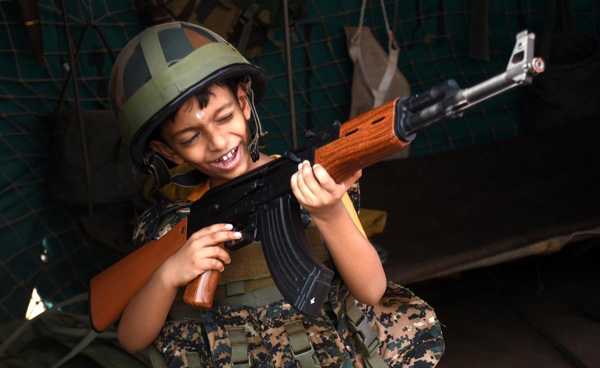 शुक्रवार को कोझिकोड में बेपोर वॉटर फेस्ट के दौरान भारतीय सेना द्वारा प्रदर्शित राइफल को महसूस करता एक बच्चा।