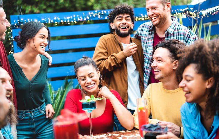 युवा वयस्कों का एक समूह जो शराब पीता है और सामाजिक होता है।